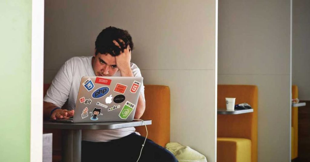 Man in White Shirt Using Macbook Pro