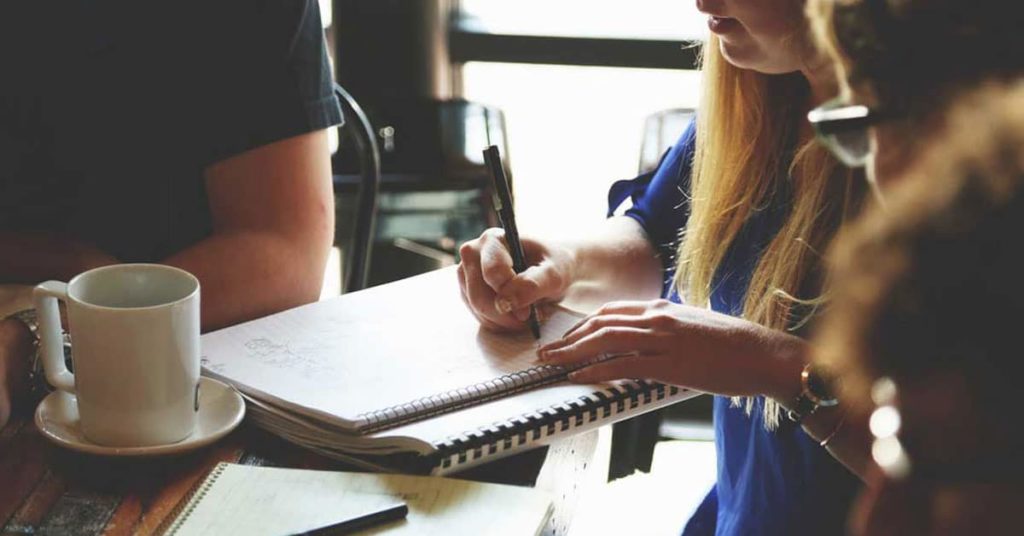 Person Writing on the Notebook