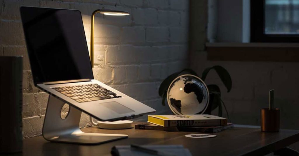 Macbook Pro on Stand Beside Desk Globe