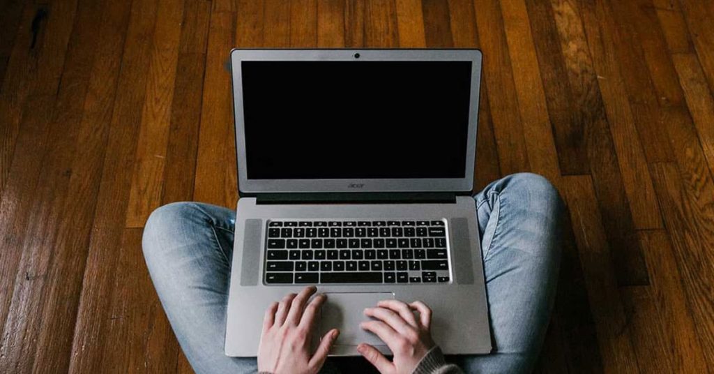 Person in Blue Denim Jeans Sitting on Floor Using Macbook Air