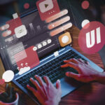 Person using a laptop with digital graphics illustrating UX and UI concepts floating above the screen, including icons, charts, and interface elements.